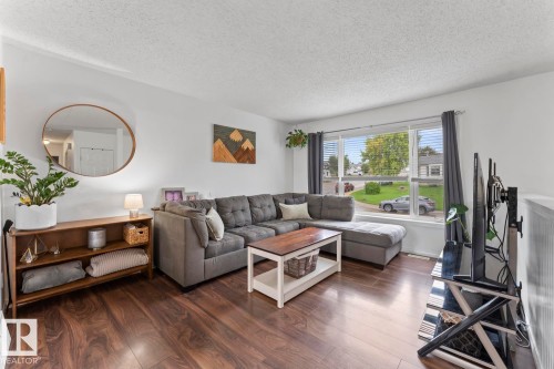 Spacious living area featuring wood-finish flooring, a large window, and light-toned walls - 5330 43 Street, Cold Lake, AB - Indoor Photo Showing Living Room