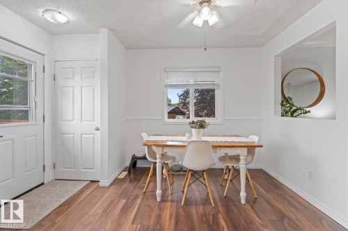 Wood-finish flooring, white paneled doors, ceiling fan with integrated lighting, built-in wall niche, and natural light from a window - 5330 43 Street, Cold Lake, AB - Indoor Photo Showing Dining Room