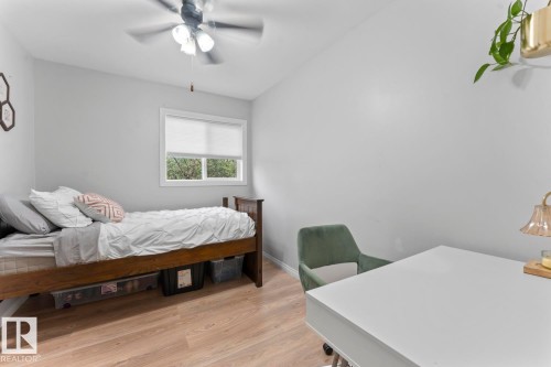 Recessed window with privacy blind, light wood-finish flooring, ceiling fan with integrated lighting, neutral wall color - 5330 43 Street, Cold Lake, AB - Indoor Photo Showing Bedroom