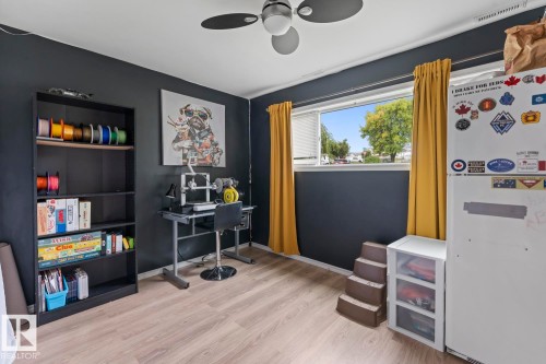Room featuring wood-finish flooring, a ceiling fan, and a window providing natural light - 5330 43 Street, Cold Lake, AB - Indoor