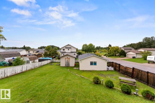 Expansive green lawn, detached storage shed, separate detached garage structure, and perimeter fencing - 5330 43 Street, Cold Lake, AB - Outdoor