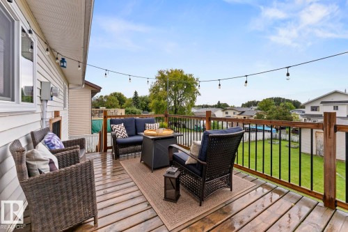 Expansive wood deck with a perimeter railing featuring wood posts and black balusters, string lighting, and direct access to the exterior - 5330 43 Street, Cold Lake, AB - Outdoor With Deck Patio Veranda With Exterior