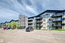 Multi-story building featuring brick and siding exterior, private balconies, and an asphalt parking area - #216 17003 67 Av Nw, Edmonton, AB  - Outdoor With Balcony With Facade 