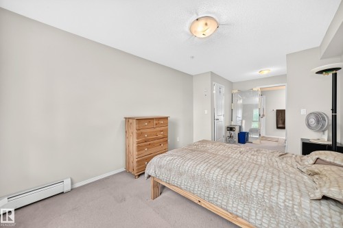 Carpeted flooring with light-colored walls - #216 17003 67 Av Nw, Edmonton, AB - Indoor Photo Showing Bedroom