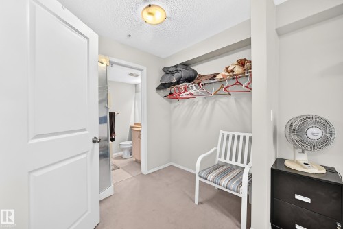 Carpeted closet space with an integrated shelf and clothing rod - #216 17003 67 Av Nw, Edmonton, AB - Indoor