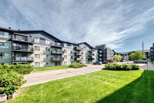 Multi-story building with dark siding and beige facade - #216 17003 67 Av Nw, Edmonton, AB - Outdoor With Balcony With Facade