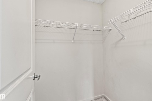 Walk-in closet featuring wire shelving and a metal door handle - #318 5521 7 Av Sw Sw, Edmonton, AB - Indoor With Storage
