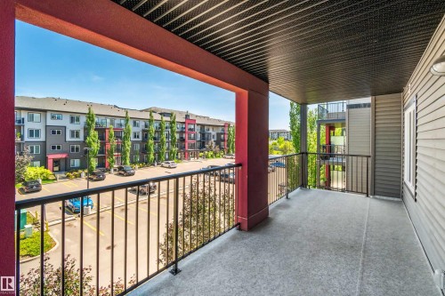 Expansive covered balcony with concrete flooring, black metal railings, and an exterior wall featuring horizontal siding - #318 5521 7 Av Sw Sw, Edmonton, AB - Outdoor With Exterior