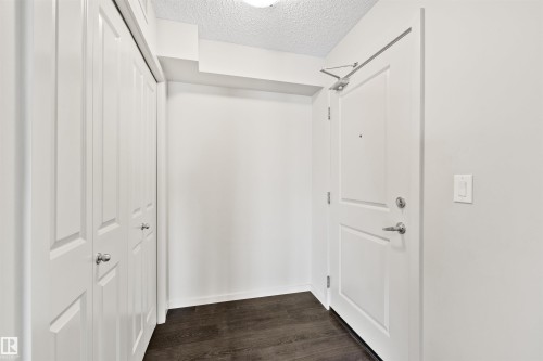 Wood-finish flooring, white walls, white paneled doors, and brushed nickel hardware - #318 5521 7 Av Sw Sw, Edmonton, AB - Indoor Photo Showing Other Room