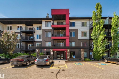 Multi-story building exterior with balconies, featuring a porte-cochere entrance, and assigned parking spaces - #318 5521 7 Av Sw Sw, Edmonton, AB - Outdoor With Facade