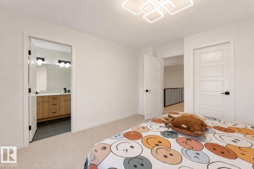 White walls throughout, carpeted flooring, and a modern ceiling light fixture - 1263 Watt Drive Sw, Edmonton, AB - Indoor Photo Showing Bedroom