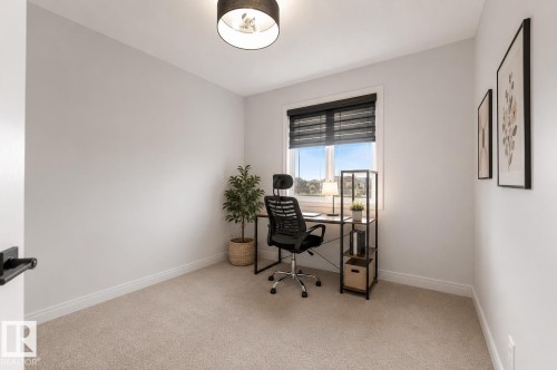 Window with dark blinds, carpet flooring, light-toned wall paint, and a ceiling-mounted light fixture - 1263 Watt Drive Sw, Edmonton, AB - Indoor Photo Showing Office