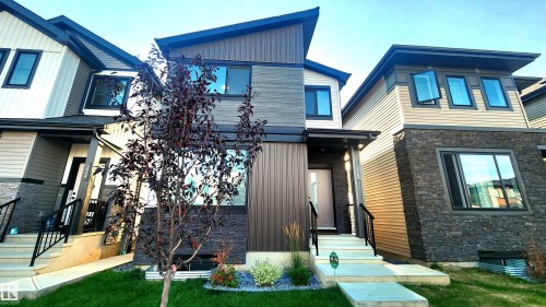 Modern exterior with mixed material siding, stone facade accents, and a distinctive sloped roofline - 220 28 Street Sw, Edmonton, AB - Outdoor