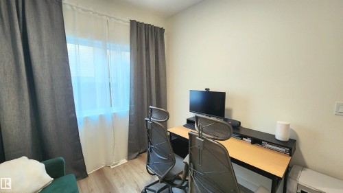 Wood-finish flooring with neutral wall tones and a window featuring dual curtain rods - 220 28 Street Sw, Edmonton, AB - Indoor Photo Showing Office