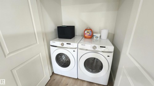 Integrated laundry area featuring wood-finish flooring - 220 28 Street Sw, Edmonton, AB - Indoor Photo Showing Laundry Room