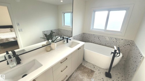 Dual vanity with integrated sinks, matte black fixtures, and light-toned cabinetry - 220 28 Street Sw, Edmonton, AB - Indoor Photo Showing Bathroom