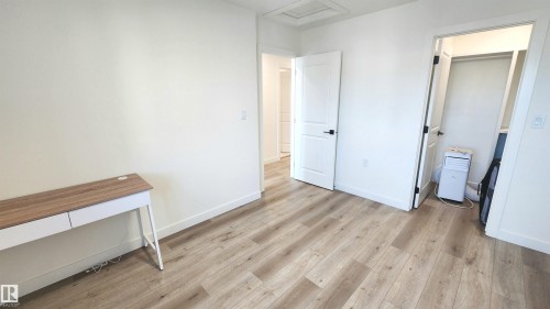 Wood-finish flooring, white walls, and white trim - 220 28 Street Sw, Edmonton, AB - Indoor Photo Showing Other Room