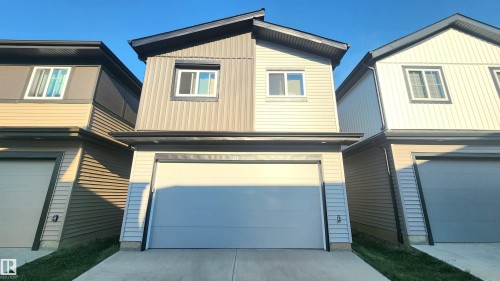 Contemporary exterior with dual-tone siding, attached garage, and contrasting dark trim - 220 28 Street Sw, Edmonton, AB - Outdoor With Exterior