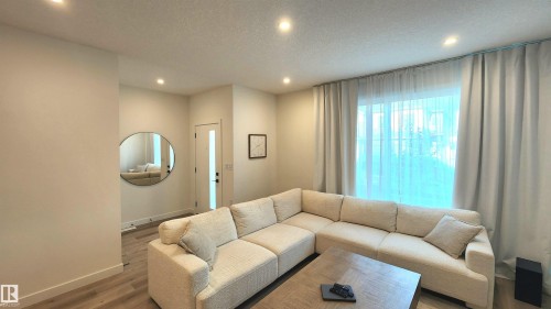 Recessed ceiling lighting illuminates light-toned walls and wood-finish flooring - 220 28 Street Sw, Edmonton, AB - Indoor Photo Showing Living Room