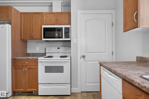 Wood-finish cabinetry paired with a coordinating countertop - 13214 123 Street Nw, Edmonton, AB 