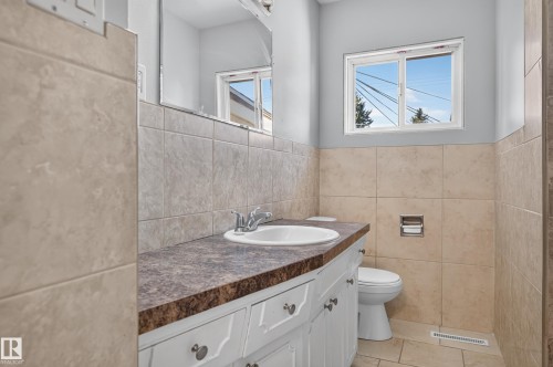 White vanity with dual-knob hardware, integrated sink, and patterned countertop - 13214 123 Street Nw, Edmonton, AB 