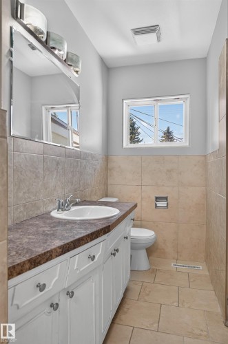 White vanity with a laminate countertop, ceramic sink, and chrome faucet - 13214 123 Street Nw, Edmonton, AB 