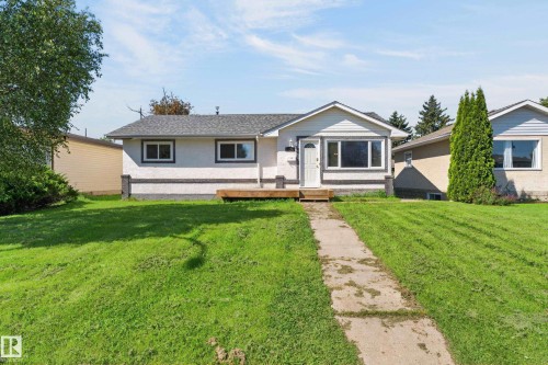 Single-story residence featuring a gabled roofline, white siding, and dark trim - 13214 123 Street Nw, Edmonton, AB 
