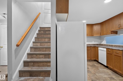 Staircase with wood handrail and tiled treads - 13214 123 Street Nw, Edmonton, AB 
