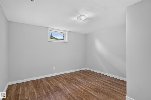Wood-finish flooring, light gray wall paint, and a built-in ceiling light fixture - 13214 123 Street Nw, Edmonton, AB 