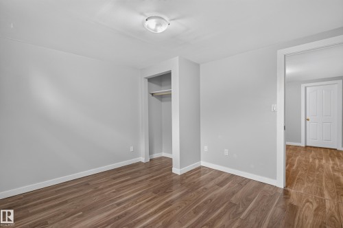 Wood-finish flooring, light gray wall paint, and overhead flush-mount lighting - 13214 123 Street Nw, Edmonton, AB 