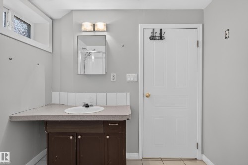 Vanity with an integrated sink, brown cabinetry, and a countertop - 13214 123 Street Nw, Edmonton, AB 
