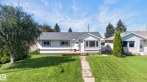 Single-story residence featuring white siding and a gray shingle roof - 13214 123 Street Nw, Edmonton, AB 