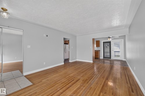 Wood-finish flooring, mirrored closet doors, and recessed ceiling fan - 13214 123 Street Nw, Edmonton, AB 