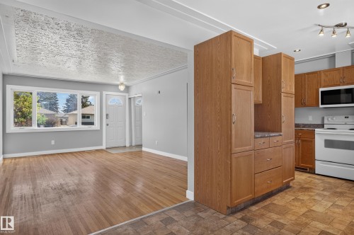Hardwood flooring, light gray wall finishes, white trim, wood cabinetry, and white appliances - 13214 123 Street Nw, Edmonton, AB 