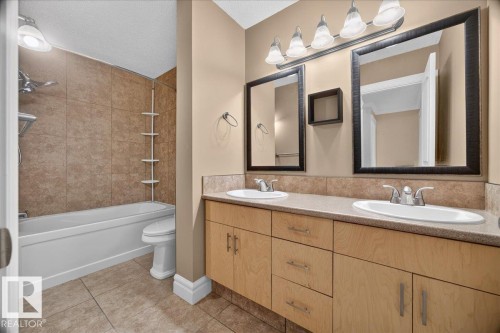 Dual vanity with integrated sinks, light wood-finish cabinetry, and framed mirrors - #47 3812 20 Av Nw, Edmonton, AB 