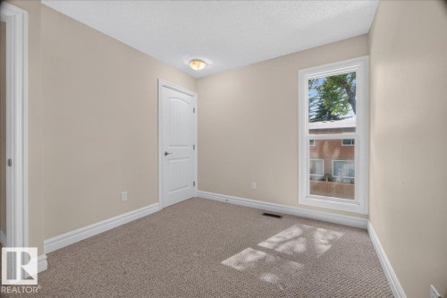 Neutral wall color, wall-to-wall carpeting, white trim, white paneled door, and a single window - #47 3812 20 Av Nw, Edmonton, AB 