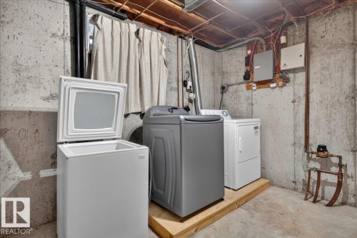 Laundry area featuring concrete walls and concrete flooring - #47 3812 20 Av Nw, Edmonton, AB 