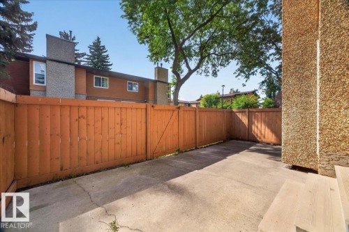 Private fenced patio with concrete surfacing and wood steps - #47 3812 20 Av Nw, Edmonton, AB 
