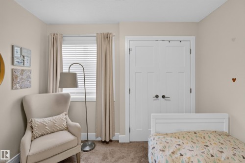 Double-door closet with dark hardware, window with white blinds, neutral wall color, and carpeted flooring - 3685 Claxton Place Sw, Edmonton, AB 