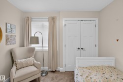 Double-door closet with dark hardware, window with white blinds, neutral wall color, and carpeted flooring - 