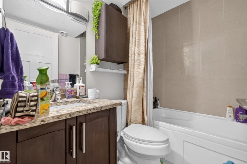 Vanity with a speckled countertop and integrated sink - 3685 Claxton Place Sw, Edmonton, AB 