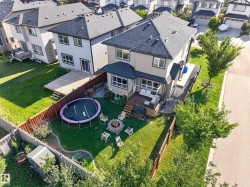 Expansive fenced backyard featuring a fire pit area, raised deck, and a secondary lower deck - 