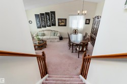 Elegant upper-level landing with hardwood railings and spindles overlooking a spacious great room - 