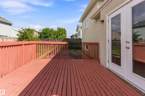 Expansive composite deck featuring rich wood-finish decking with metal railings and integrated stair access - 17724 94 Street Nw, Edmonton, AB 