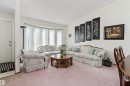 Bright and spacious living room flooded with natural light through expansive multi-pane windows dressed with sheer curtains - 17724 94 Street Nw, Edmonton, AB 