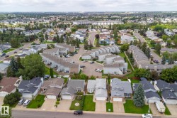 Residential neighborhood featuring various architectural styles, mature trees, and paved roads - 