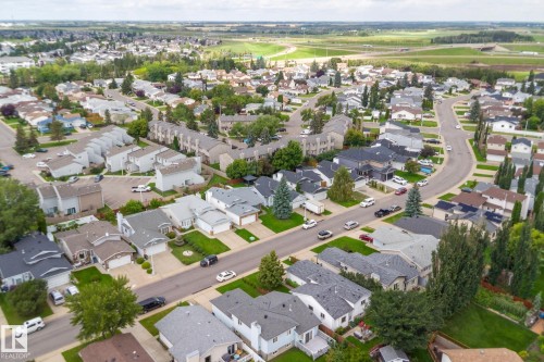 Residential neighborhood featuring varied housing styles, mature trees, and paved streets - 17724 94 Street Nw, Edmonton, AB 