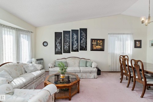 Vaulted ceiling, bay window, light wall tones, carpet flooring, window with sheer curtains - 17724 94 Street Nw, Edmonton, AB 