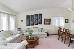 Vaulted ceiling, bay window, light wall tones, carpet flooring, window with sheer curtains - 