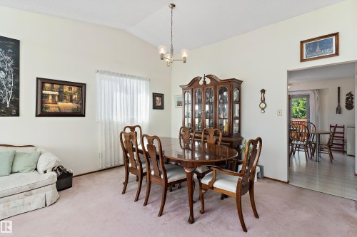 Vaulted ceiling with an overhead light fixture, window with sheer coverings, and an entry opening to another room - 17724 94 Street Nw, Edmonton, AB 